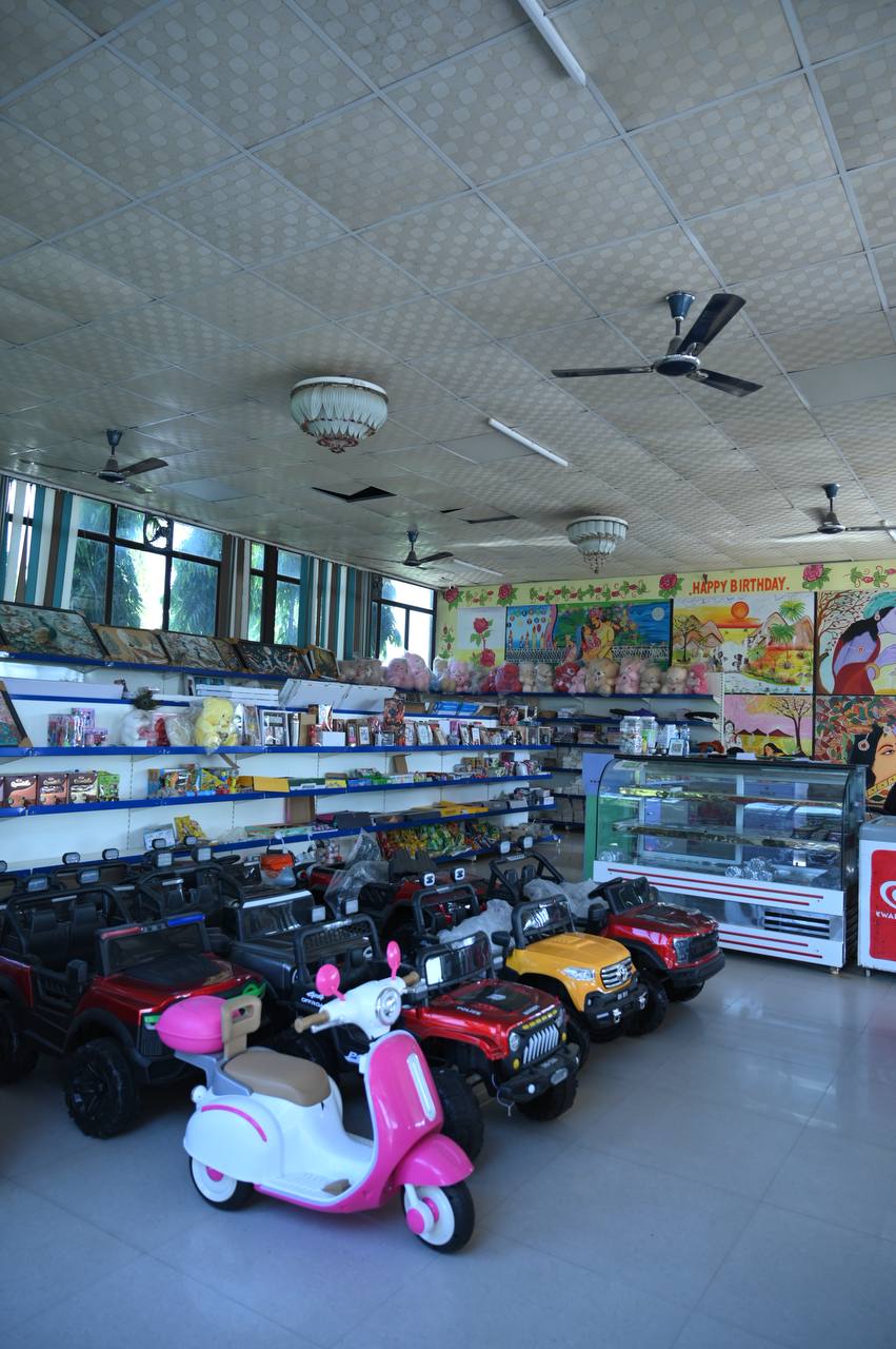 Mini-mart interior with display shelves, a counter and toy vehicles.